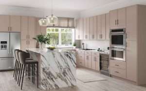 Modern kitchen with marble island and beige cabinets.