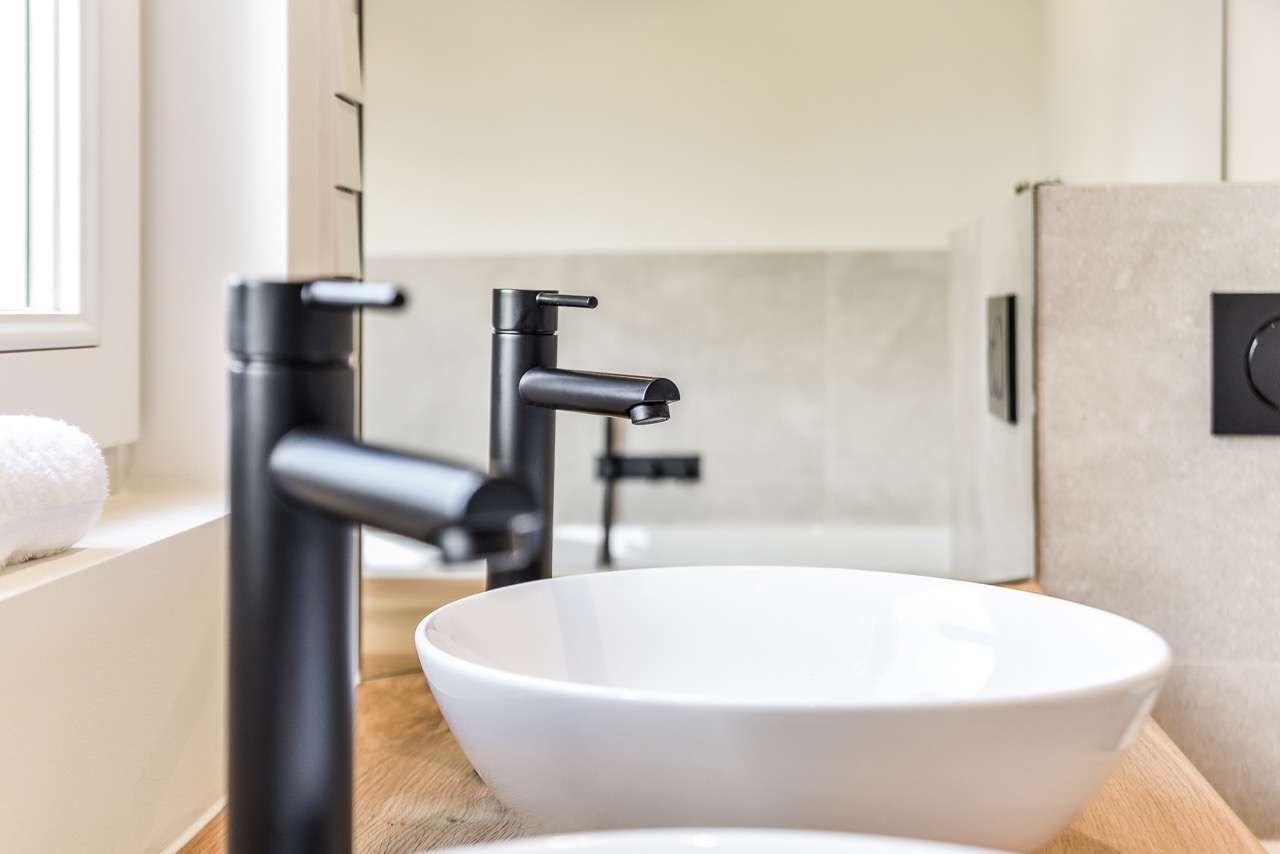 Modern bathroom sink with black faucet and mirror
